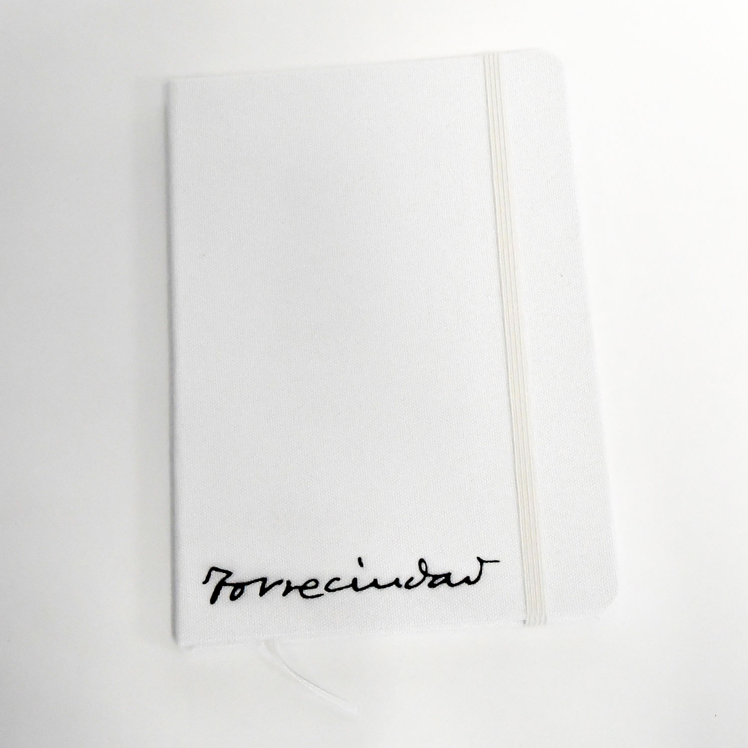 Libreta blanca con la tipografía de Torreciudad en color negro